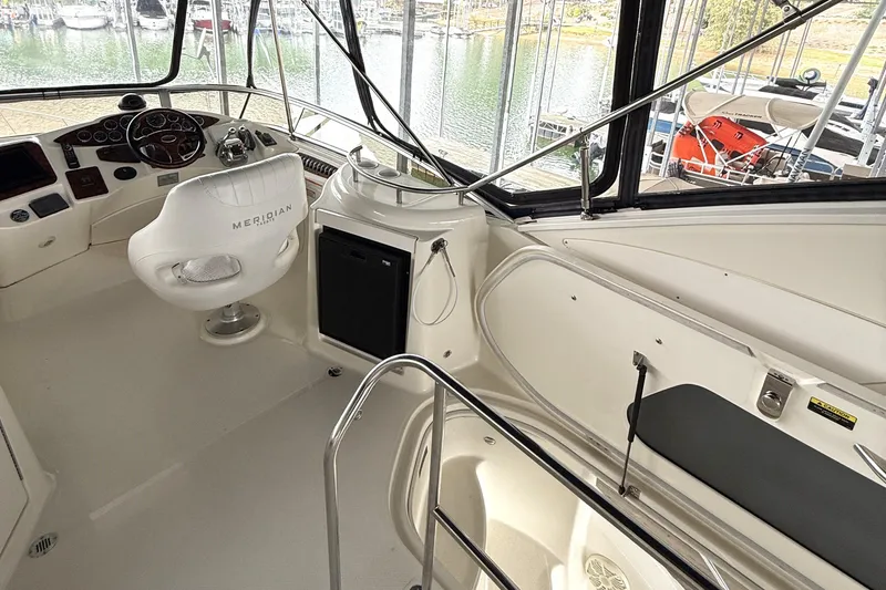 Slide: The Image of 2008 Meridian 391 yacht cockpit with helm, white seating, and marina view. - 16