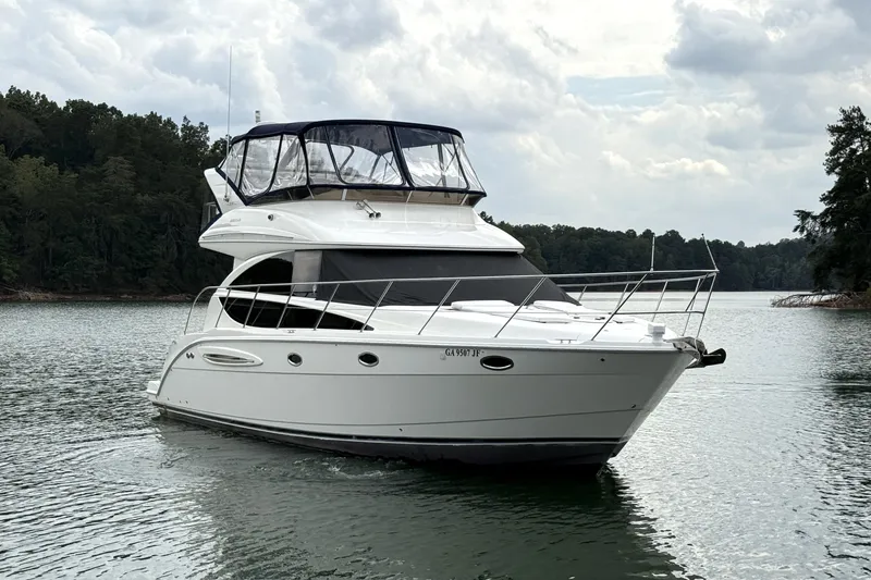 Slide: The Image of 2008 Meridian 391 yacht cruising on a serene lake under cloudy skies. - 4