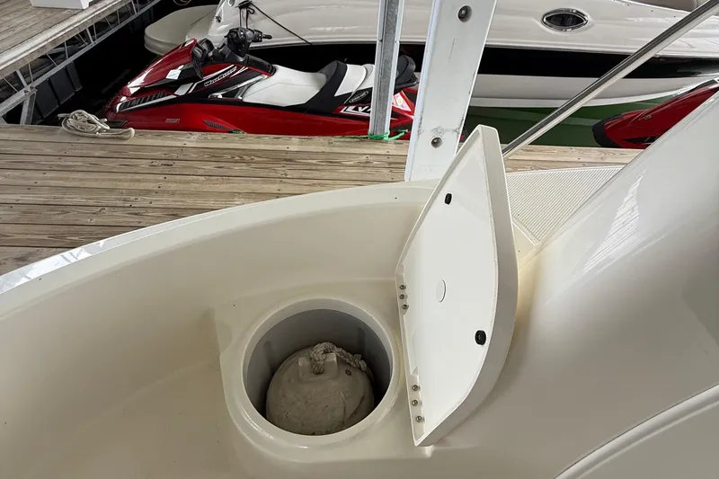 Slide: The Image of 2008 Meridian 391 boat with open storage compartment, docked near a red jet ski. - 43