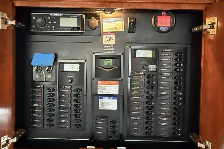 Slide: The Image of Electrical control panel inside a 2008 Meridian 391 boat, featuring switches and gauges. - 49