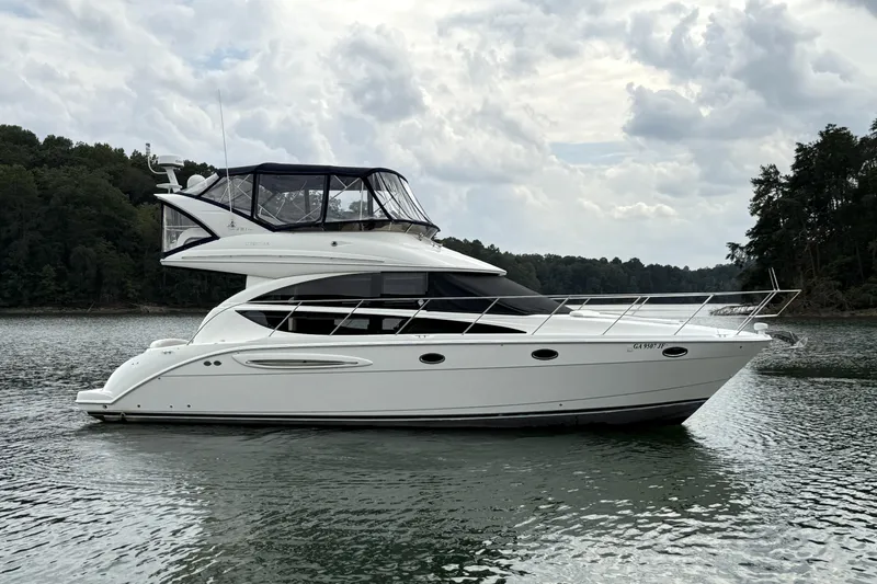 Slide: The Image of 2008 Meridian 391 yacht on a serene lake with cloudy sky backdrop. - 5