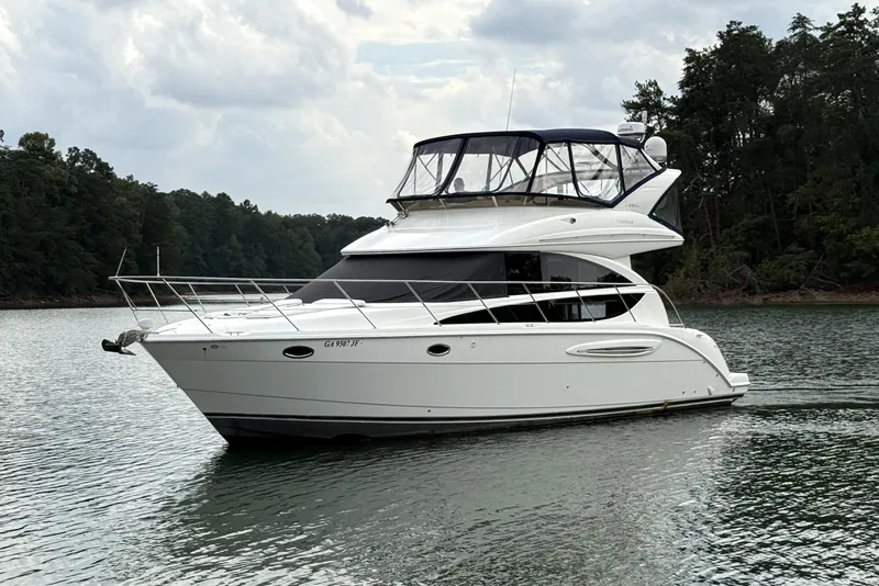 Slide: The Image of 2008 Meridian 391 yacht cruising on a serene lake with forested shoreline. - 7