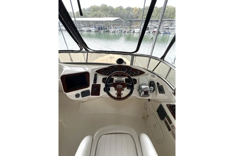 Slide: The Image of 2008 Meridian 391 yacht helm with steering wheel and control panel, overlooking marina. - 8