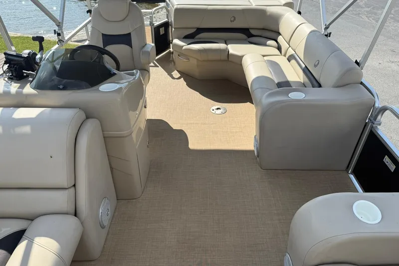 Slide: The Image of 2015 Lowe SS 230 pontoon boat interior with beige seating and steering console. - 10