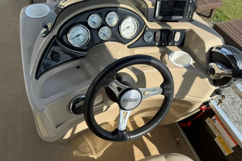 Slide: The Image of Steering console of a 2015 Lowe SS 230 boat with gauges and controls. - 14