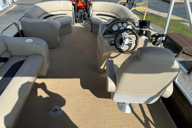 Slide: The Image of 2015 Lowe SS 230 pontoon boat interior with beige seating and steering console. - 20