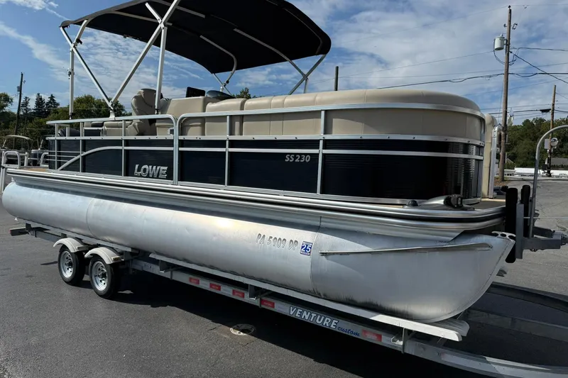 Slide: The Image of 2015 Lowe SS 230 pontoon boat on trailer under blue sky. - 7