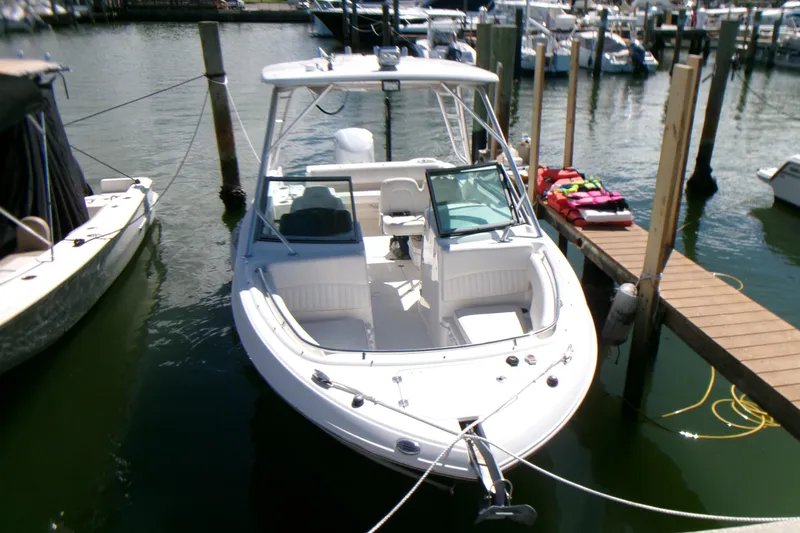 Slide: The Image of 2012 Robalo R247 Dual Console boat docked at marina, front view. - 10
