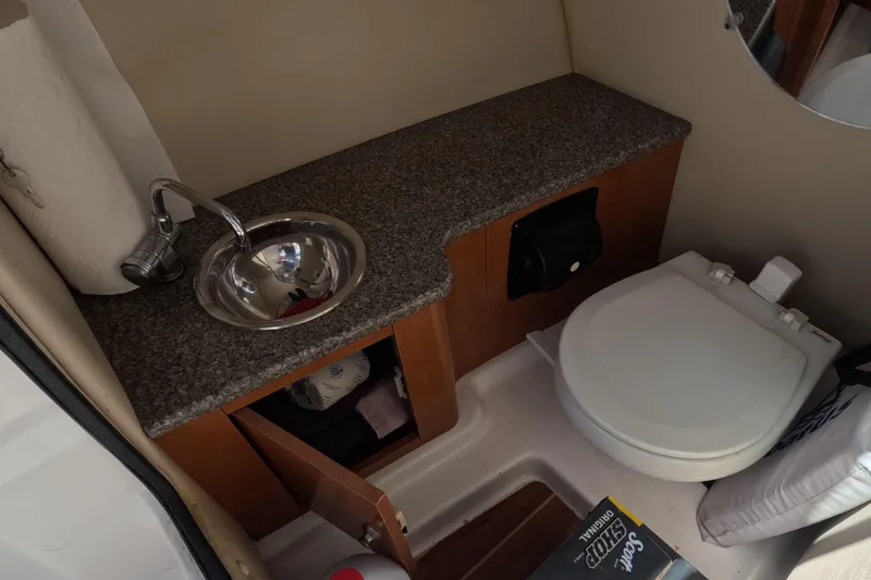 Slide: The Image of 2012 Robalo R247 Dual Console boat interior with toilet and countertop. - 100