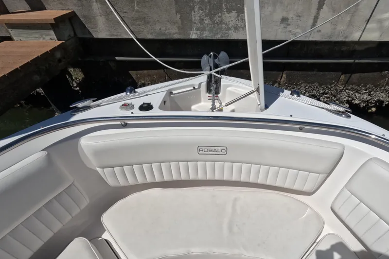 Slide: The Image of 2012 Robalo R247 Dual Console boat with open anchor compartment at dock. - 103