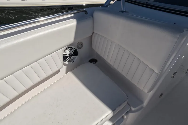 Slide: The Image of 2012 Robalo R247 Dual Console boat interior with white cushioned seating and speaker. - 106