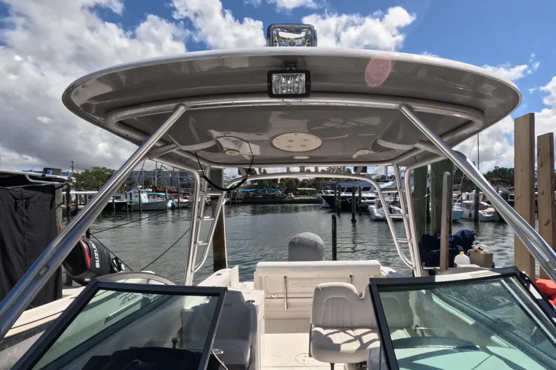 Slide: The Image of 2012 Robalo R247 Dual Console boat interior with white seating and speaker. - 107