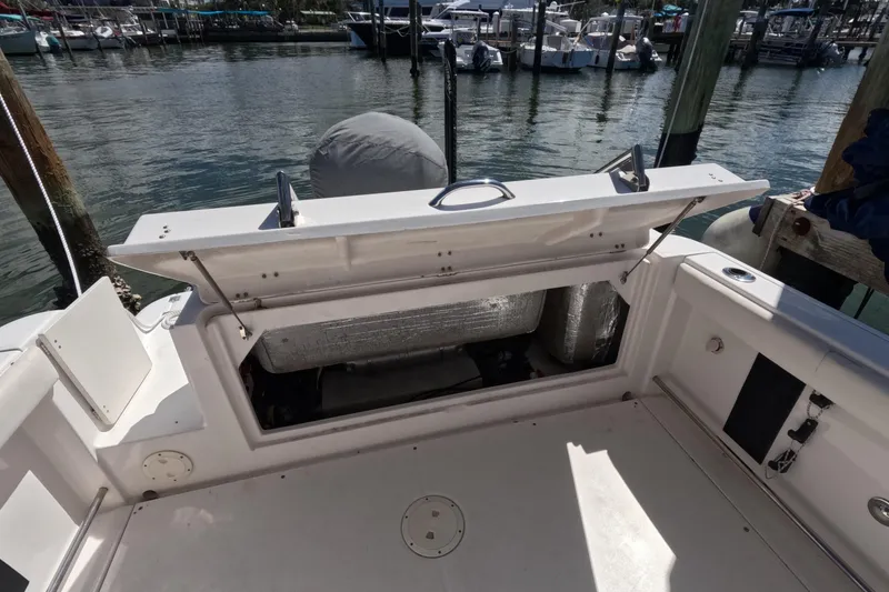 Slide: The Image of 2012 Robalo R247 Dual Console boat docked at marina under blue sky. - 108