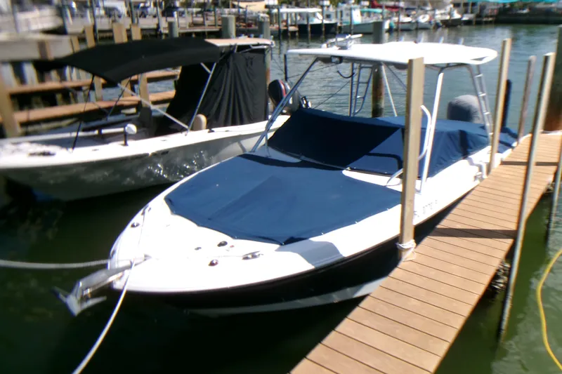 Slide: The Image of 2012 Robalo R247 Dual Console boat docked with blue covers. - 11