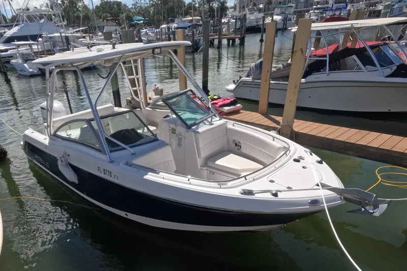 Slide: The Image of 2012 Robalo R247 Dual Console boat docked with life jackets on the pier. - 113