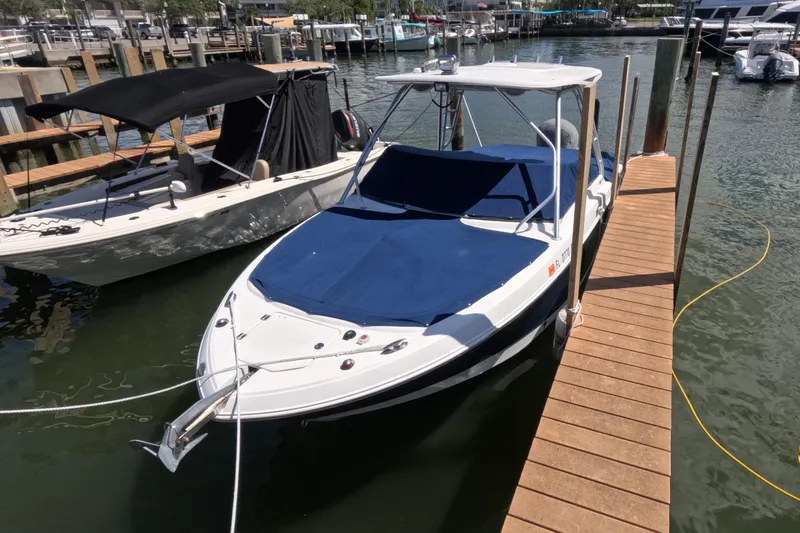 Slide: The Image of 2012 Robalo R247 Dual Console boat docked, featuring spacious seating and sleek design. - 115
