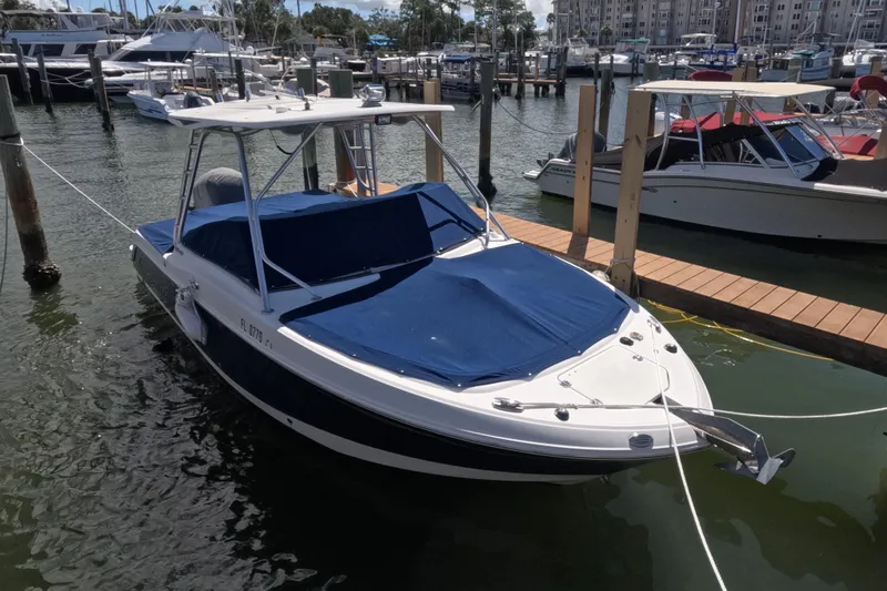 Slide: The Image of 2012 Robalo R247 Dual Console boat docked with blue covers. - 116
