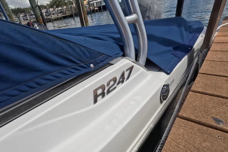 Slide: The Image of 2012 Robalo R247 Dual Console boat docked with blue cover in marina. - 117