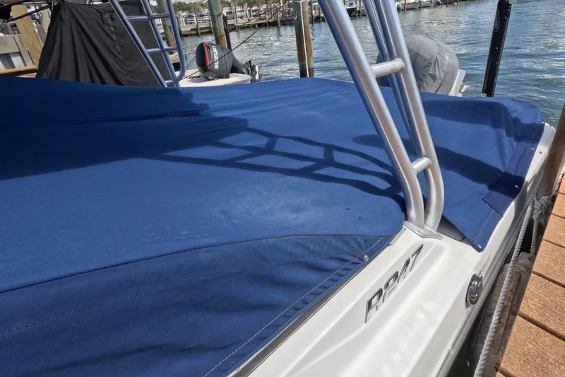 Slide: The Image of 2012 Robalo R247 Dual Console boat docked with blue cover. - 118