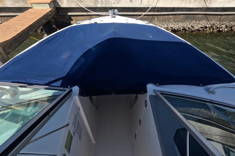 Slide: The Image of 2012 Robalo R247 Dual Console boat with blue cover at dock. - 12