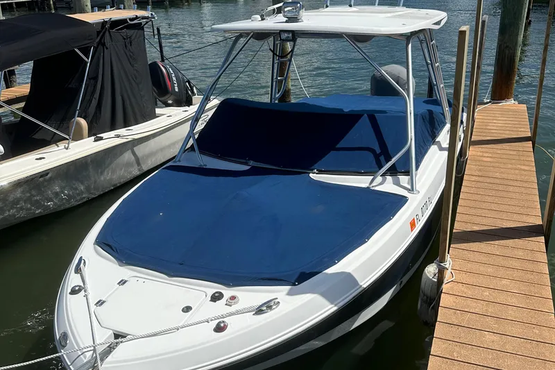 Slide: The Image of 2012 Robalo R247 Dual Console boat docked with blue cover. - 122