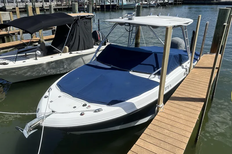 Slide: The Image of 2012 Robalo R247 Dual Console boat docked with blue cover. - 123