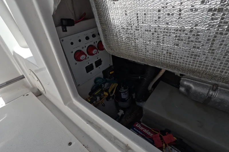 Slide: The Image of 2012 Robalo R247 Dual Console boat electrical panel and battery compartment. - 14