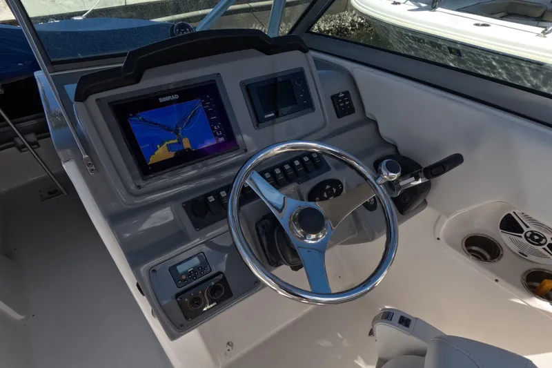 Slide: The Image of 2012 Robalo R247 Dual Console boat dashboard with steering wheel and navigation display. - 16