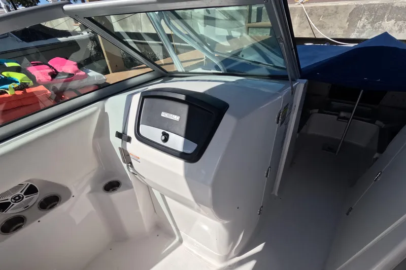 Slide: The Image of 2012 Robalo R247 Dual Console boat interior with storage and colorful life jackets. - 17