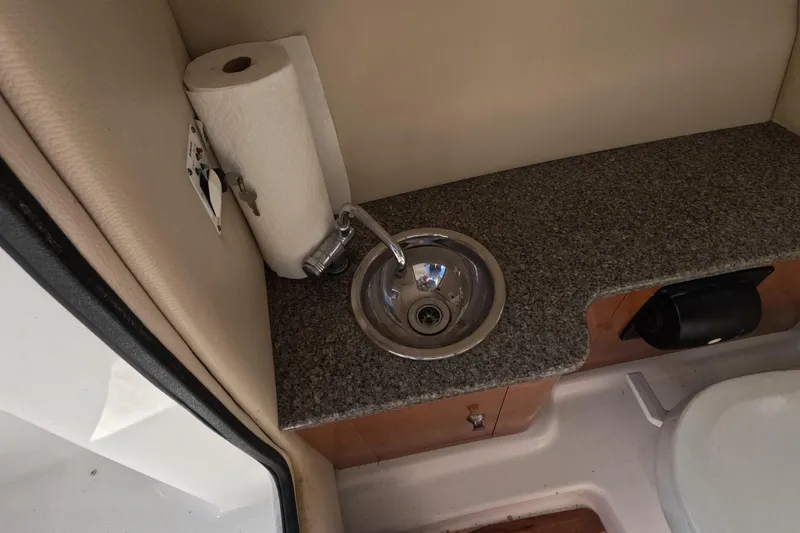 Slide: The Image of 2012 Robalo R247 Dual Console boat interior with sink and countertop. - 18