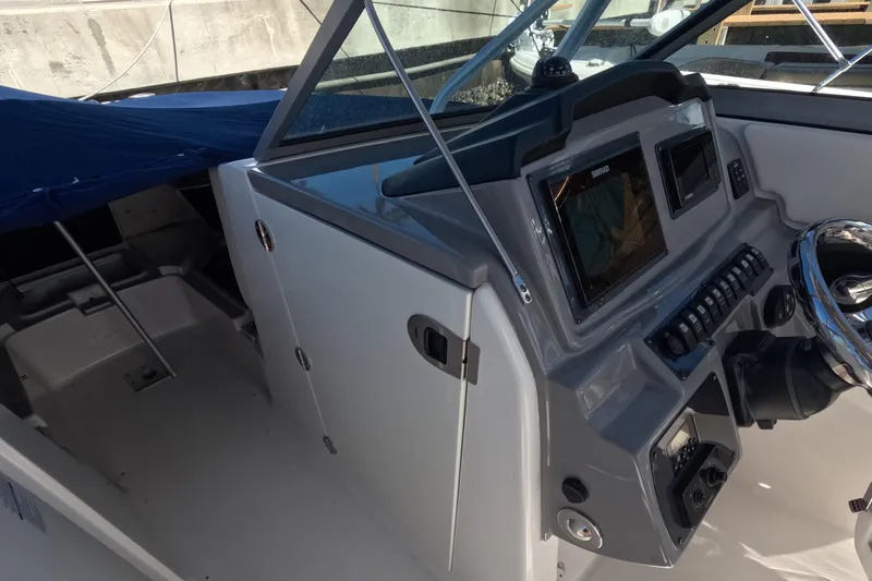 Slide: The Image of 2012 Robalo R247 Dual Console boat interior with steering wheel and control panel. - 21