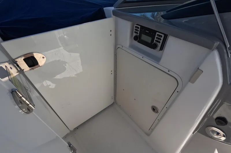 Slide: The Image of 2012 Robalo R247 Dual Console interior with control panel and storage compartment. - 22