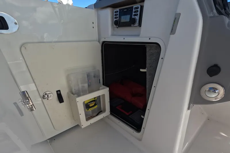 Slide: The Image of 2012 Robalo R247 Dual Console storage compartment with equipment and control panel. - 23