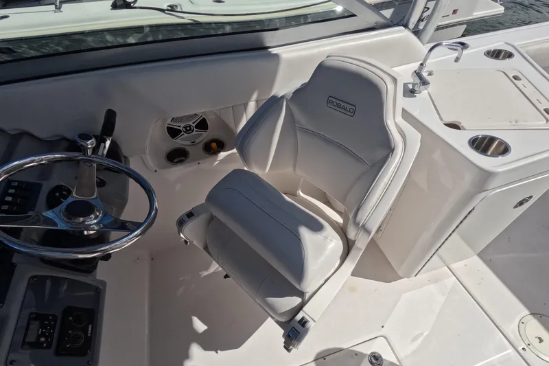 Slide: The Image of 2012 Robalo R247 Dual Console boat interior with steering wheel and seating. - 25
