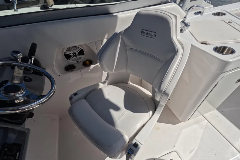 Slide: The Image of 2012 Robalo R247 Dual Console boat interior with steering wheel and seating. - 26