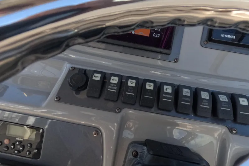 Slide: The Image of Control panel of 2012 Robalo R247 Dual Console boat with various switches and displays. - 33
