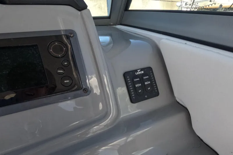 Slide: The Image of 2012 Robalo R247 Dual Console dashboard with Lenco trim tab controls. - 34