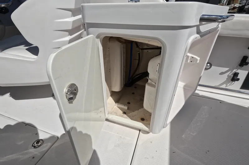 Slide: The Image of 2012 Robalo R247 Dual Console boat storage compartment with open door. - 37