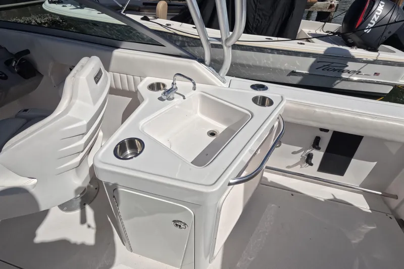 Slide: The Image of 2012 Robalo R247 Dual Console boat interior with sink and seating area. - 38