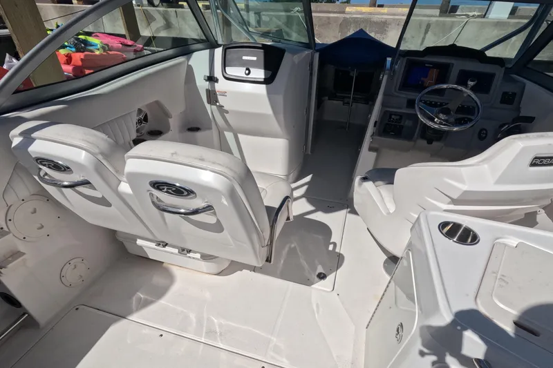 Slide: The Image of 2012 Robalo R247 Dual Console boat interior with white seating and steering console. - 39