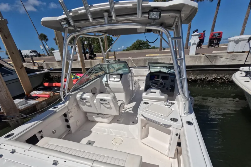 Slide: The Image of 2012 Robalo R247 Dual Console boat docked, featuring spacious seating and modern controls. - 4