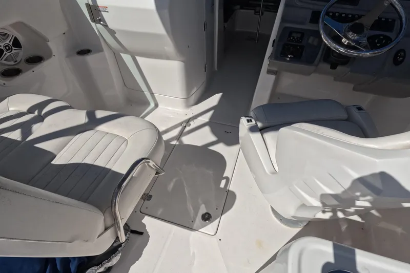 Slide: The Image of 2012 Robalo R247 Dual Console boat interior with white seating and steering area. - 49