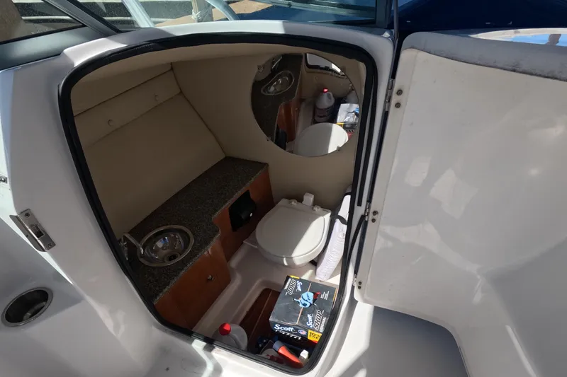 Slide: The Image of 2012 Robalo R247 Dual Console boat interior with compact bathroom amenities. - 6