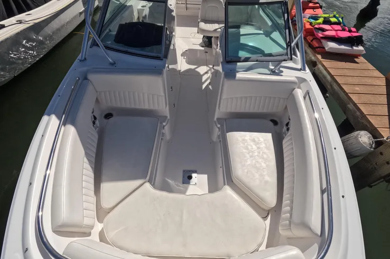 Slide: The Image of 2012 Robalo R247 Dual Console boat with spacious seating and docked life jackets. - 60