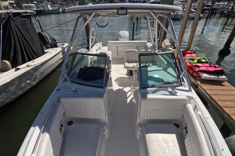 Slide: The Image of 2012 Robalo R247 Dual Console boat docked, featuring spacious seating and modern design. - 61