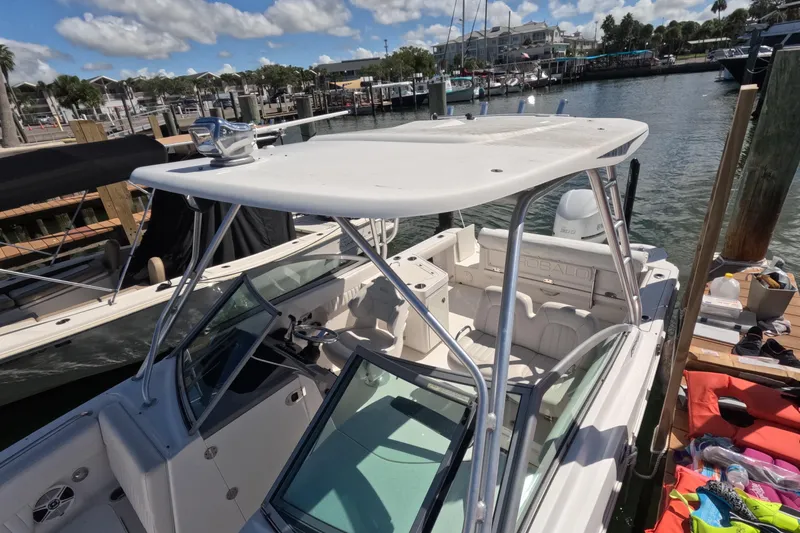 Slide: The Image of 2012 Robalo R247 Dual Console boat docked at marina under clear skies. - 62