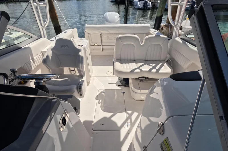 Slide: The Image of 2012 Robalo R247 Dual Console boat interior with white seating and steering wheel. - 63