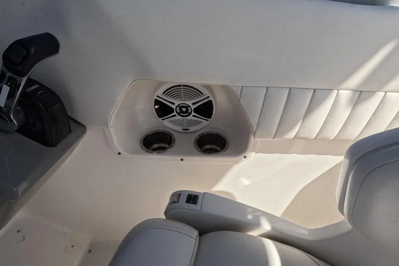 Slide: The Image of 2012 Robalo R247 Dual Console interior with speaker and cup holders. - 67