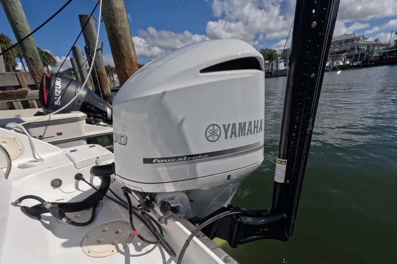 Slide: The Image of 2012 Robalo R247 Dual Console with Yamaha outboard motor docked by the water. - 73