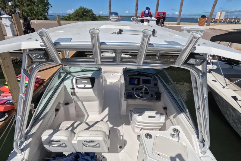Slide: The Image of 2012 Robalo R247 Dual Console boat interior with helm, seating, and rod holders. - 75